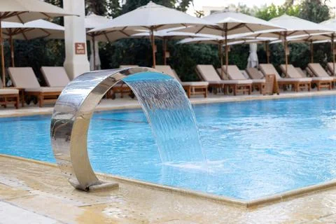 Modern Pool with Waterfall Feature and Lounge Chairs Stock Photos