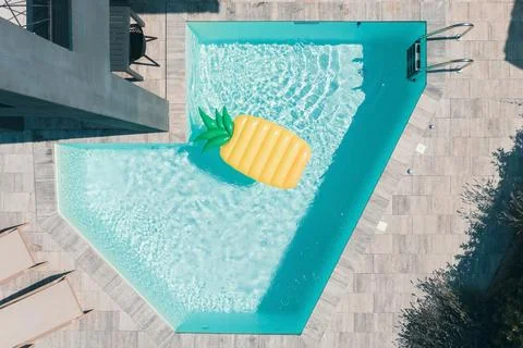 Modern Pool with Yellow Pineapple Float, Aerial View Foto stock
