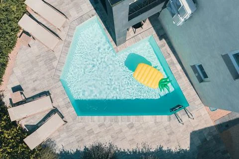 Modern Pool with Yellow Pineapple Float, Aerial View Foto stock