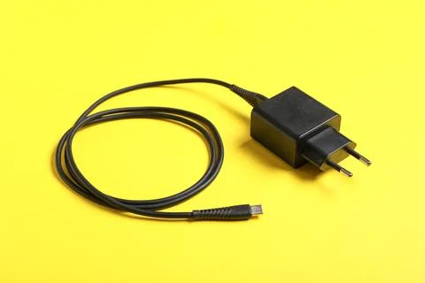 Modern power adapter with type-c cable on yellow background, closeup Stock Photos