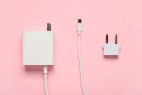 Modern power adapter, USB cable and plug head on pink background, top view Stock Photos