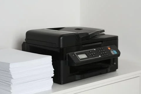 Modern printer and paper sheets on white table indoors Foto stock