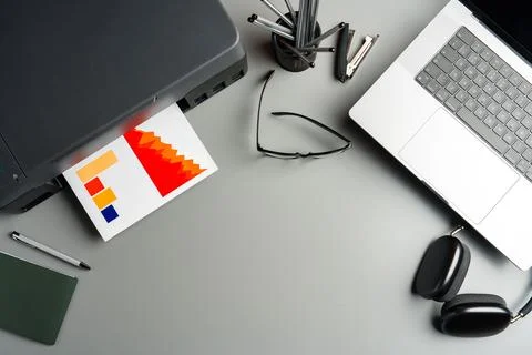 Modern printer with paper and laptop on table in office Stock Photos