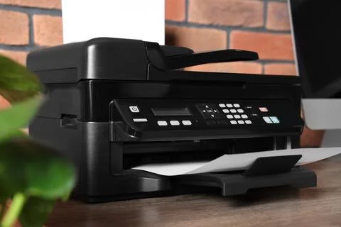 Modern printer with paper near computer on wooden desk at home 스톡 사진