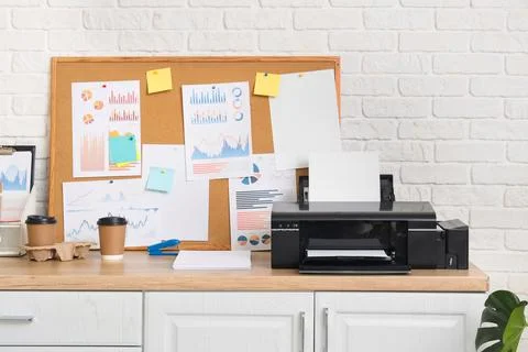 Modern printer with paper sheets and pin board on shelf in office Stock Photos