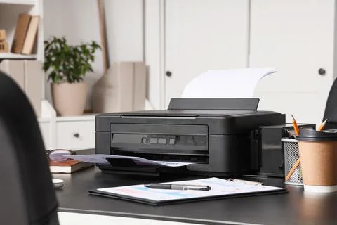 Modern printer with paper sheets on table in office Stock Photos
