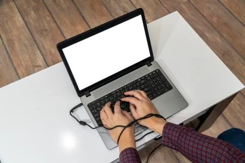 Modern problems concept. Man typing on laptop with hands tangled in the cable Stock Photos