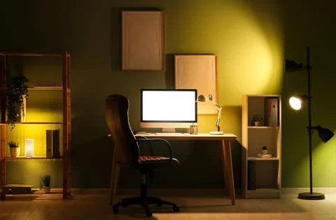 Modern programmer's workplace with computer monitor, shelving units and glowi Stock-Fotos