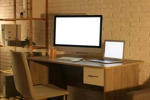 Modern programmers workplace with computer monitor, laptop and shelving unit  Stock Photos