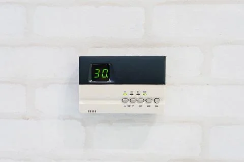 Modern programming thermostat in front of white brick wall with copyspace a.. Stock Photos