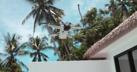Modern quadcopter drone hovering in the air on background of blue summer sky Stock-Footage 250064382