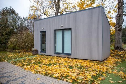 Modern Rectangular Structure Amidst Autumn Foliage and Mature Trees 스톡 사진
