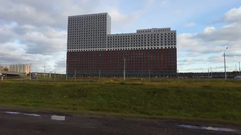 Modern Red And Gray Office Building In Open Field Under Blue Sky And Clouds Video stock 325839807