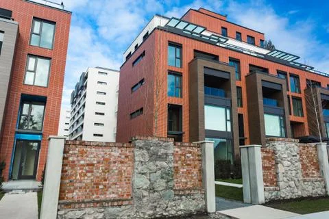 Modern Red Brick Apartment Complex with solid rock fence wall. Home residenti Stock Photos