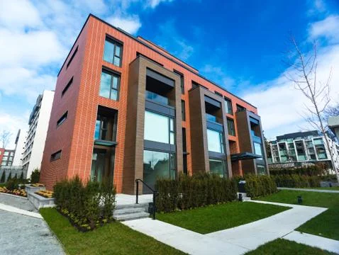 Modern Red Brick Apartment Complex with solid rock fence wall. Home residenti Stock Photos