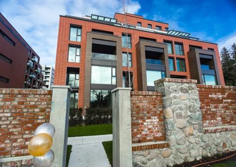 Modern Red Brick Apartment Complex with solid rock fence wall. Home residenti Stock Photos