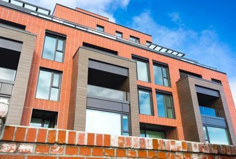 Modern Red Brick Apartment Complex with solid rock fence wall. Home residenti Stock Photos