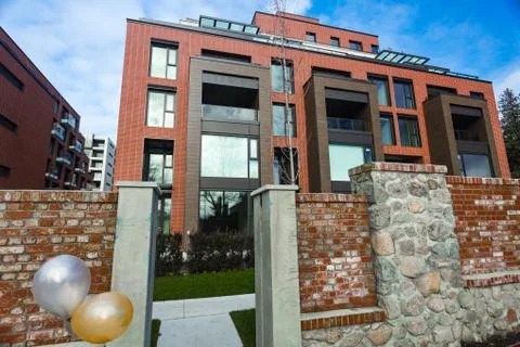 Modern Red Brick Apartment Complex with solid rock fence wall. Home residenti Stock Photos
