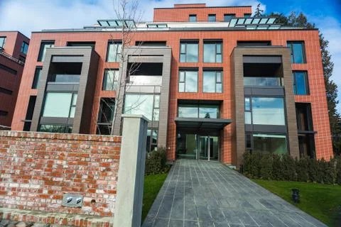 Modern Red Brick Apartment Complex with solid rock fence wall. Home residenti Stock Photos