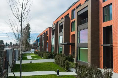 Modern Red Brick Apartment Complex with solid rock fence wall. Home residenti Stock Photos