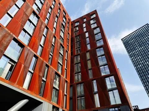 Modern red facade building with geometric windows in Manchester, UK, low an.. Stock Photos