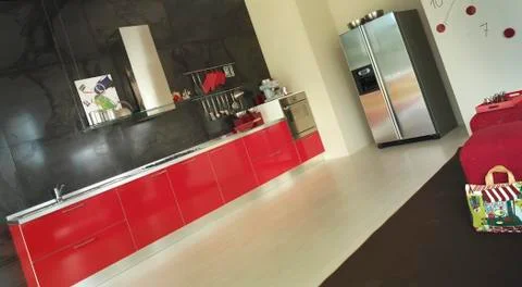 Modern red kitchen interior and steel refrigerator Stock Photos