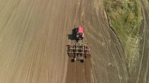 Modern Red Tractor With A Chisel Cultivator Prepares Fertile Soil For Sowing On Stock Footage 138910413