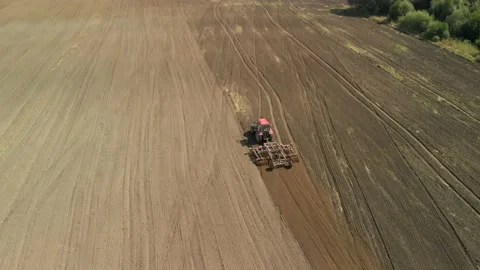 Modern Red Tractor With A Chisel Cultivator Prepares Fertile Soil For Sowing On Vídeos de archivo 138973738