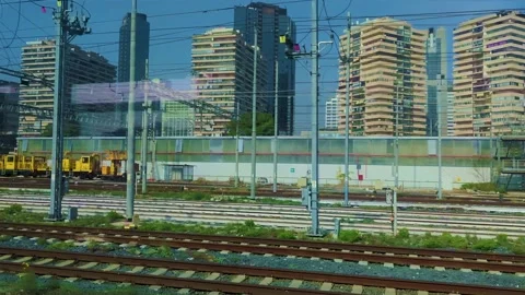 A Modern Red Train Against a Blue Sky and Skyscrapers on a Warm Summer Day. Stock Footage 231575112