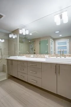 Modern refreshing bathroom features a beige dual washstand accented with mosa Stock Photos