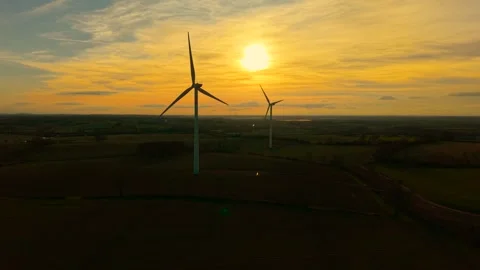 Modern renewable fuel technologies at sunset. Wind turbine rotating strong rotor Stock Footage 312784076