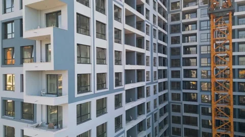 Modern residential building construction site with yellow tower crane facade Stock Footage 346233624