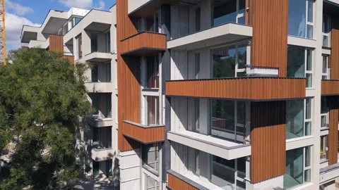 Modern Residential Building Under Construction with Yellow Tower Crane and Sky Stock Footage 346697623