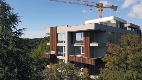Modern Residential Building Under Construction with Yellow Tower Crane and Sky Stock Footage 346698096