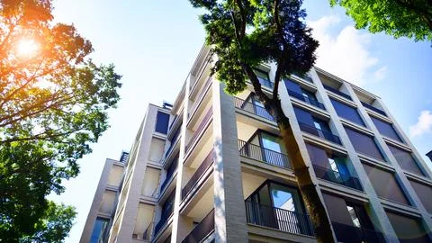 A modern residential building in the vicinity of trees. Stock Photos
