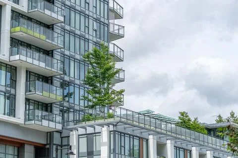 Modern Residential Condominium Building With Glass Balconies Under Cloudy Sky Stock Photos