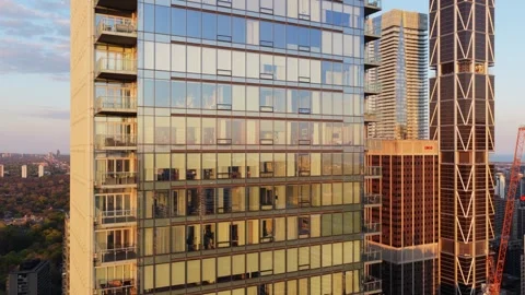 Modern residential tower facade with glass windows reflecting Toronto skyline at Stock Footage 335225770