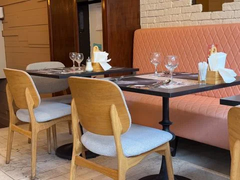 Modern restaurant interior with quilted bench seating and neatly arranged d.. Stock Photos