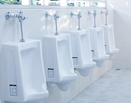 Modern restroom interior with urinal row . Stock Photos