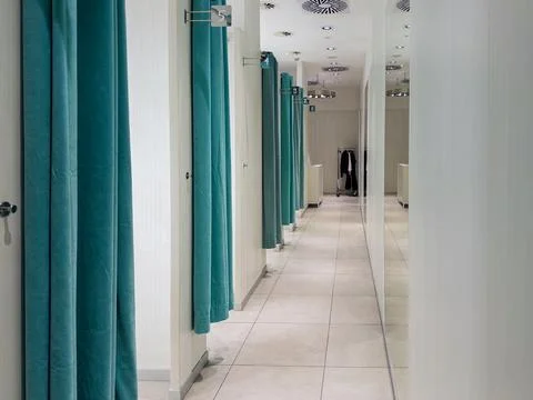 Modern retail store fitting room corridor featuring multiple empty numbered.. Stock Photos