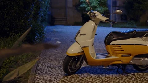 Modern retro style white and yellow motor scooter parked on a cobblestone s.. Stock Footage 335859083
