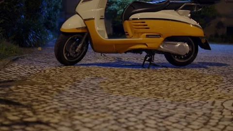 Modern retro style white and yellow motor scooter parked on a cobblestone s.. Stock-Footage 335859092