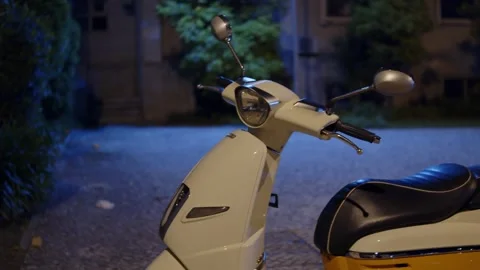 Modern retro style white and yellow motor scooter parked on a cobblestone s.. Stock Footage 335859095