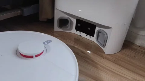 Modern robot vacuum cleans shiny hardwood floors Stock Footage 340142755