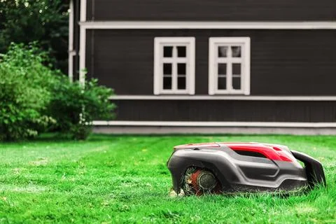 A modern robotic lawn mower automatically cuts grass.Ideal for smart home, .. Stock Photos