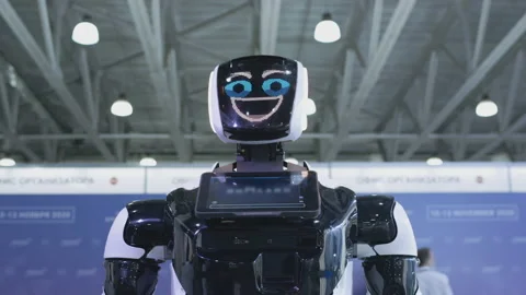 Modern Robotic Technologies. The robot looks at the camera at the person. The Video stock 144176648