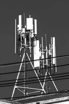 Modern rooftop 5G base station on building against blue sky city communicat.. Stockfoto's