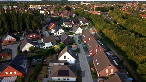 Modern rooftop solar panels glow beneath golden sunset light over red-tiled Stock Footage 340566135