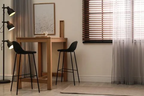 Modern room interior with table set, window blinds and stylish decor elements Foto stock