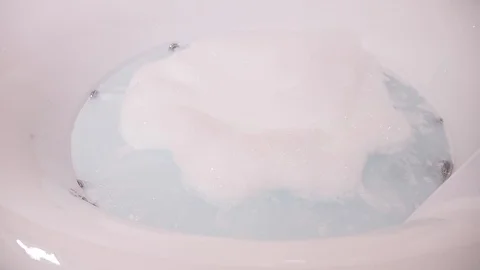 A modern round bath with a jacuzzi, filled with bubbling water with soap foam Vidéo 89477309